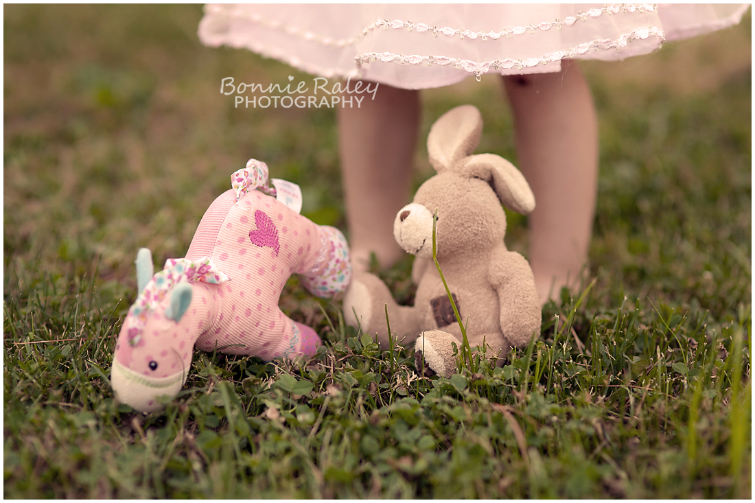 stuffed animals in grass with girl