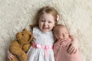 Main Line Philadelphia newborn photography featuring big sister holding newborn baby
